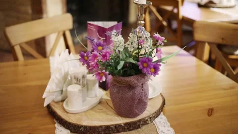 Vase with lilac flowers on a cut of a tree on a Stock Footage 299636096