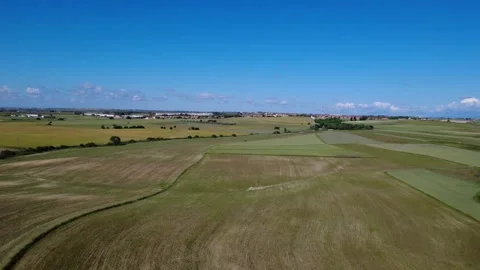 Vast agricultural landscape with fields and village in the distance Stock Footage 310017606