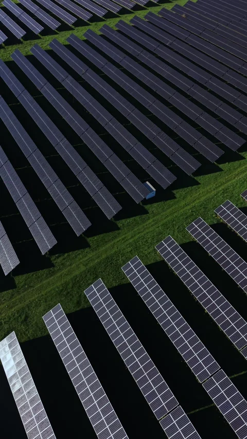 Vast array of solar panels generating clean energy in a green field under a Video stock 332038092