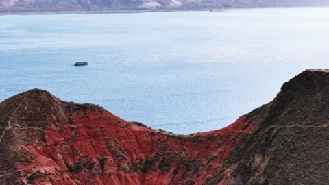 Vast Blue Lake Framed by Dramatic Red Mountains with a Boat China Stock Footage 346590241