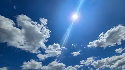 Vast blue sky filled with soft white clouds inspires calm, clarity, and a s.. Stock Photos