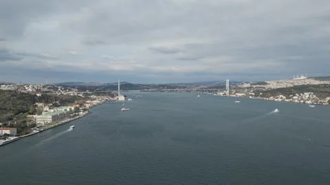 Vast blue strait with a distant suspension bridge under a cloudy sky. Stock Footage 328920035