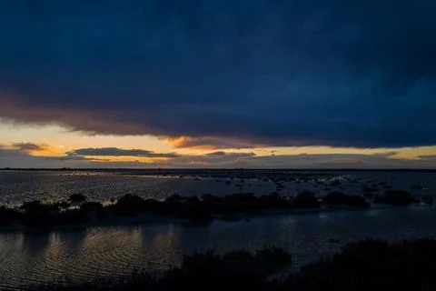Vast Camargue marsh under dramatic twilight sky Stock Photos