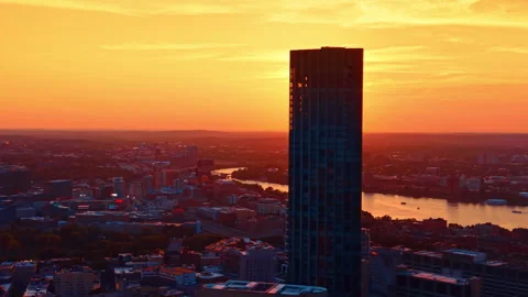 Vast cityscape dazzled by the bright setting sun. Drone flight along the dark Stock Footage 340477298