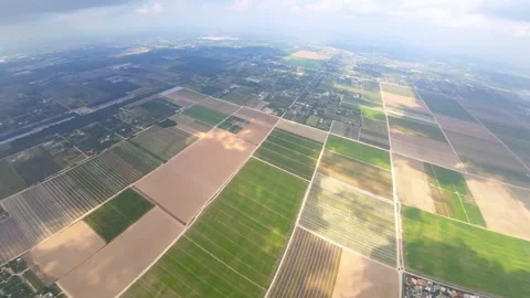 Vast cityscape with farmlands divided into rectangular fields in the middle. Stock Footage 285537338