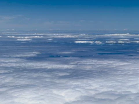 Vast cloud layer stretches beneath clear blue sky Fotos Stock