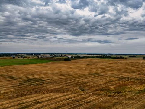 Vast Drone Landscape Dry Fields, Wind Turbines, and Intense Clouds Stock Photos