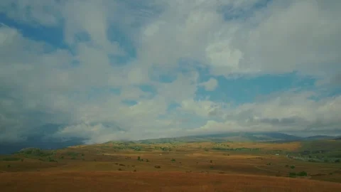 Vast dry grassland stretching under dramatic cloudy sky in Durmitor Stockbeeldmateriaal 342800177