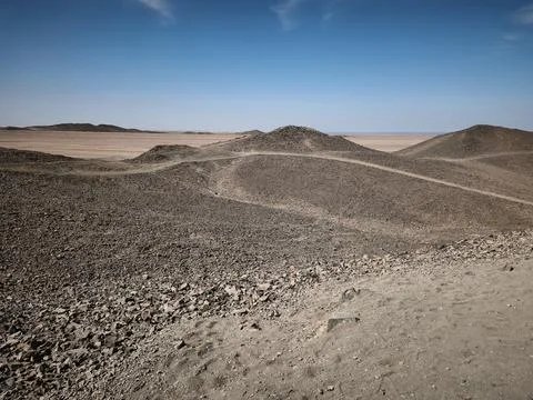 Vast Egyptian desert panorama with rolling sand dunes, rugged rocky terrain.. Stock Photos