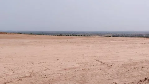 Vast empty field of bare soil under daytime light blue sky Stock Footage 307059225