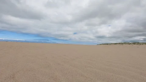 Vast, empty sandy beach under a cloudy sky Stock Footage 281835861