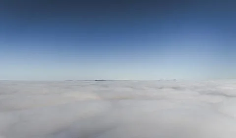 Vast expanse of clouds with distant landmass visible on the horizon Fotos de archivo