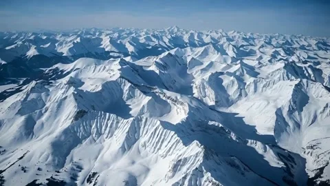 Vast expanse of snow capped mountain peaks stretching to horizon under brig.. Stock-Footage 321948181