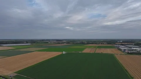 Vast farmland with patchwork fields under a cloudy sky, aerial view Stock Footage 284453472