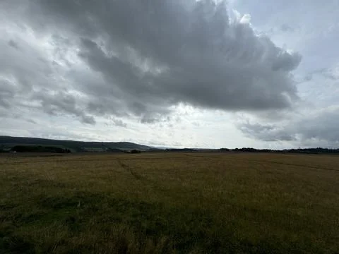 Vast Field Under Cloudy Sky Stock Photos