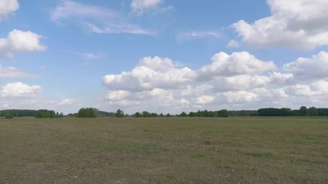 A vast field under a partly cloudy sky in 4k slow motion 60fps Stock Footage 282534659