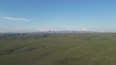 A vast, flat green plain extending toward low hills on the horizon. Stock Footage 334447723