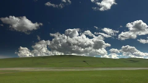 Vast grassland under dramatic clouds - Atmospheric Weather and Pastoral Expanse Stock Footage 339717487