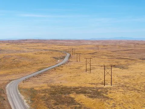 Vast grasslands stretch under a clear blue sky Stock Photos