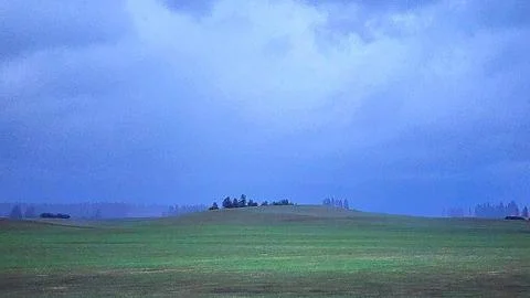 Vast Green Field Under Dramatic Cloudy Sky Stock Photos