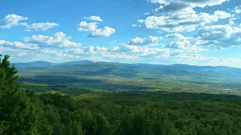 Vast green hills stretch beneath a bright blue sky. Pirot Panorama, Serbia Video stock 335536019