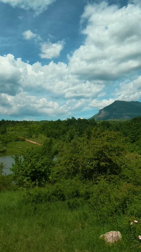 Vast green hills stretch beneath a vast. Vrmdza Lake, Serbia. Vertical Video stock 338029902