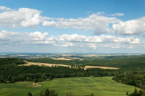 Vast green valley with fields and forests and wind turbines on the horizon Foto stock