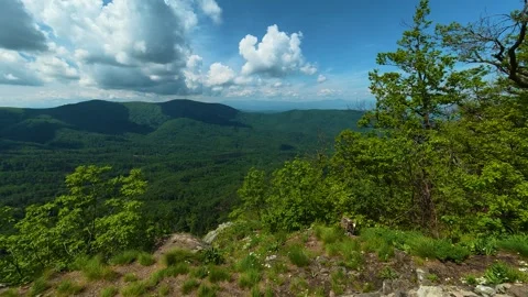 Vast green valleys stretch beneath rocky outcrops. Jastrebac Mountain, Serbia. Stock-Footage 336024179