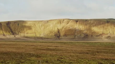 Vast Icelandic Landscape with a Cliff Face and Grassy Plain Stock Footage 320517503