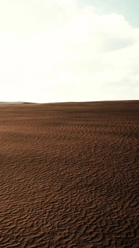 Vast landscape of dry earth with distant hills and bright sky overhead Stock Footage 346757644
