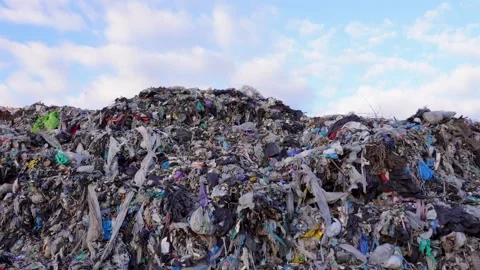 A vast mountain of mixed garbage and plastic waste covers the landscape und.. Stock Footage 321918142