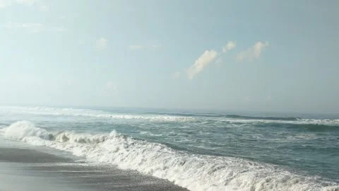 A vast ocean with large, rolling waves. The waves are crashing onto a sandy.. Video stock 285195875