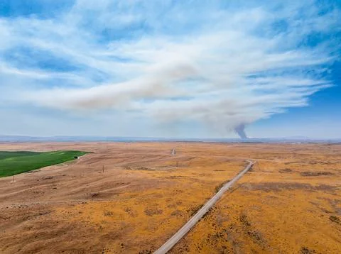 Vast open field under a clear sky with clouds Stock Photos
