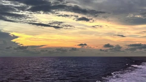 Vast Open Ocean Sunset View with Golden Clouds and Boat Wake Stock Footage 320095575