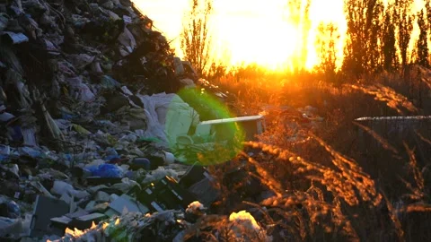 A vast pile of waste material lit by a warm sunset glow creates a stark vis.. Stock Footage 321918182