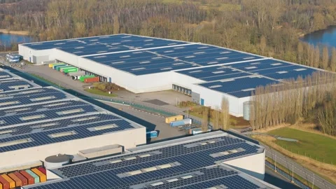 Vast rectangular warehouse dark blue solar arrays loading docks trailers Video stock 329079509
