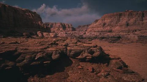 Vast rocky landscape under a dramatic sky with clouds at sunset Stock Illustration