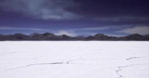 Vast salt flat under a dramatic sky in a remote mountainous region Illustrazione stock