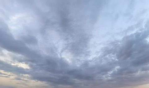 Vast sky filled with dynamic clouds displays a blend of hues at dusk, creating a 스톡 사진