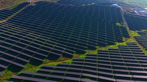 Vast solar panel array capturing sunlight in a remote green landscape while Stock Footage 335360038