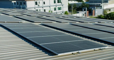 A vast solar panel array is generating power on an industrial factory roof, focu Stock Footage 330255004