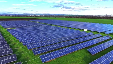 Vast solar panel array in a green field under clear blue skies Stock Footage 325088488