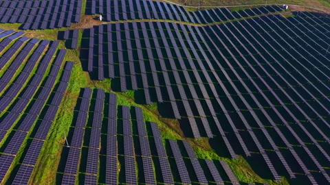 Vast solar panel array harnesses sunlight in a green landscape during bright Stock-Footage 331947659