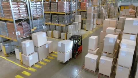 A vast warehouse filled with stacked boxes and crates on metal racks. 库存影片 307999934