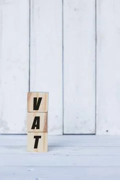 Vat concept written on wooden cubes or blocks, on white wooden background. Stock Photos