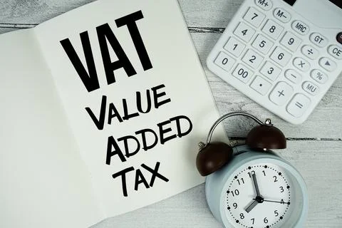 VAT Value Added Tax text on paper notebook page with alarm clock and calcul.. Stock Photos