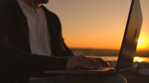 Vault plan of a hand typing on a laptop keyboard at sunset with a view of the Vídeos de archivo 118195275