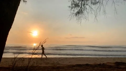 VDO summer activity with man jogging on beach with sunrise background Stock Footage 148158123