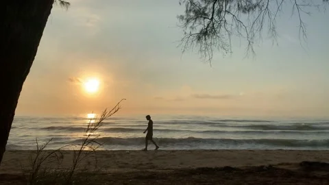 VDO summer activity with man walking on beach with sunrise background Stock Footage 148158569