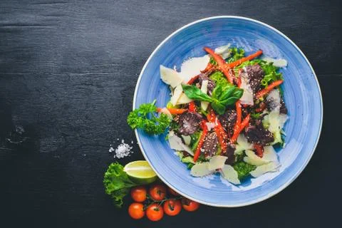 Veal and fresh vegetables salad. On a wooden background. Top view. Free space Stock Photos